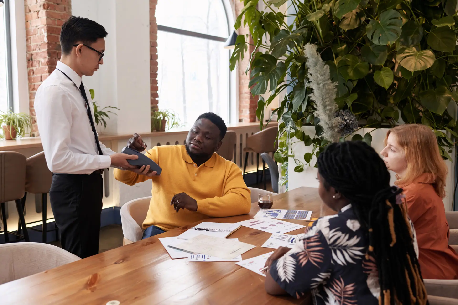 Young Businessman Paying For Lunch In Restaurant
